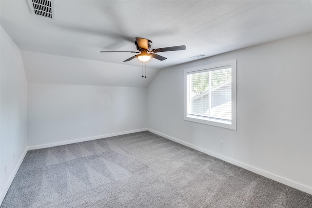 additional living space with lofted ceiling, a textured ceiling, ceiling fan, and carpet