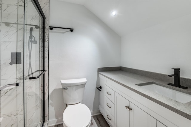 full bathroom with lofted ceiling, vanity, a marble finish shower, and toilet