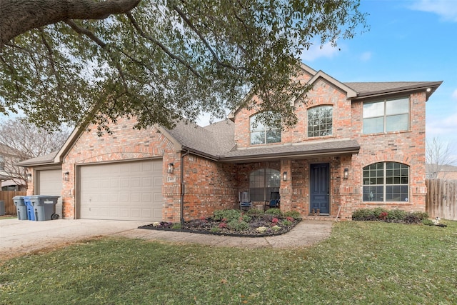 traditional-style house with an attached garage, brick siding, fence, driveway, and a front yard