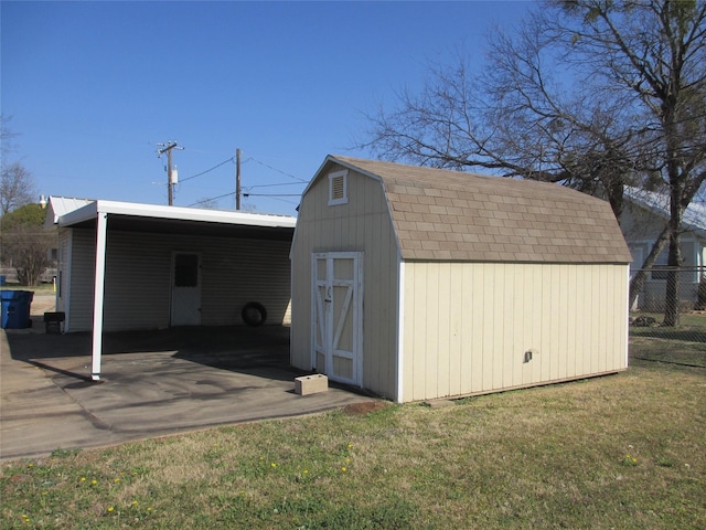 view of outbuilding featuring a carport and a yard