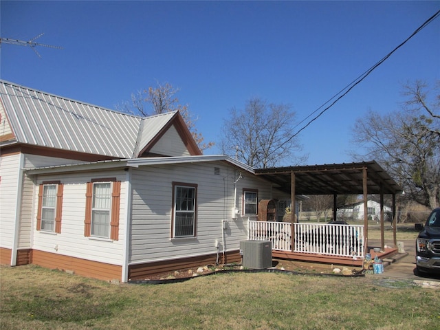 view of property exterior with central AC, a porch, and a yard