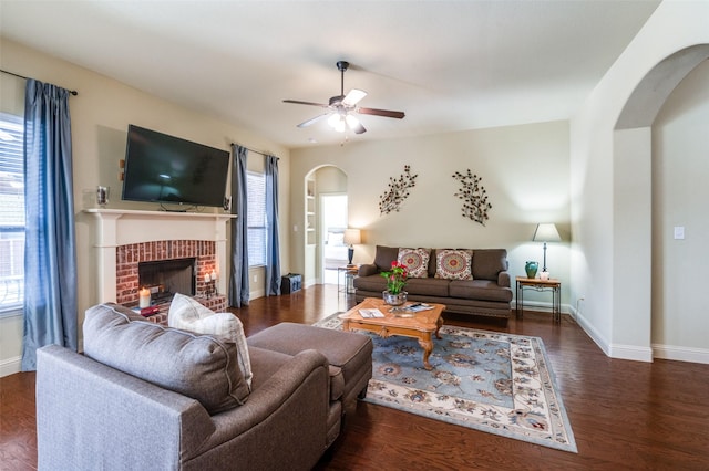 living room with ceiling fan, a fireplace, and dark hardwood / wood-style flooring