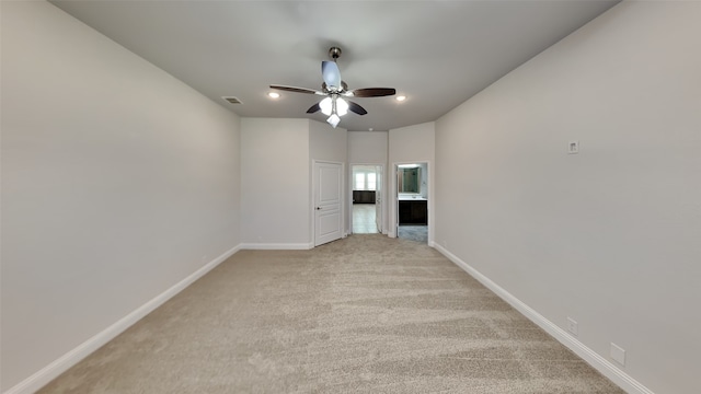 carpeted spare room featuring ceiling fan