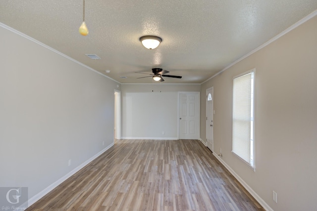 empty room featuring light hardwood / wood-style flooring, ornamental molding, and a healthy amount of sunlight