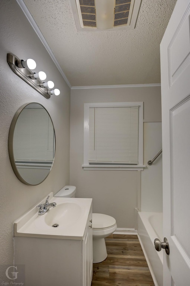 bathroom featuring toilet, crown molding, a textured ceiling, vanity, and hardwood / wood-style flooring