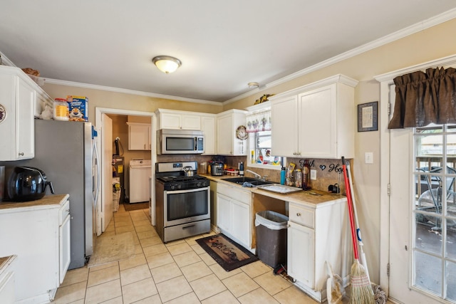 kitchen featuring appliances with stainless steel finishes, sink, decorative backsplash, and white cabinets