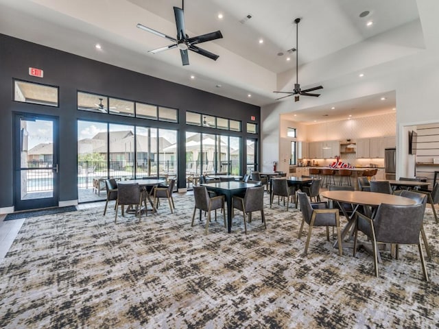 dining area featuring ceiling fan and a high ceiling