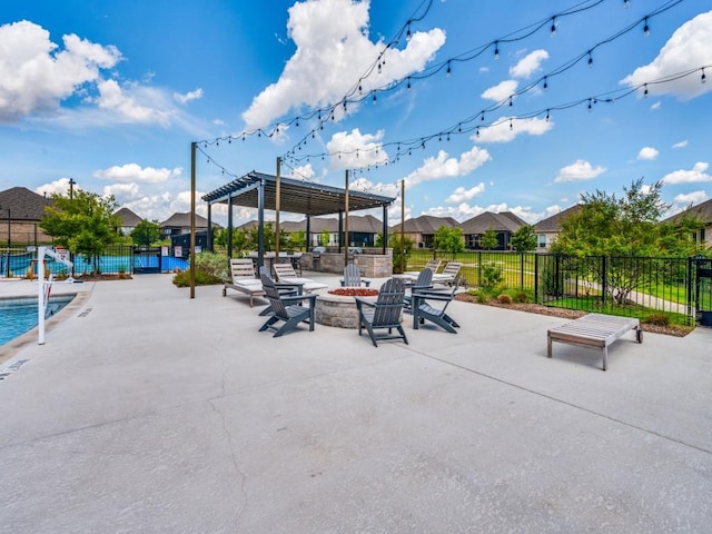 view of patio / terrace with an outdoor fire pit, fence, a community pool, a pergola, and a residential view