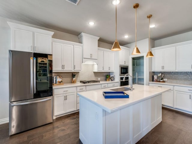 kitchen featuring stainless steel appliances, hanging light fixtures, and white cabinets