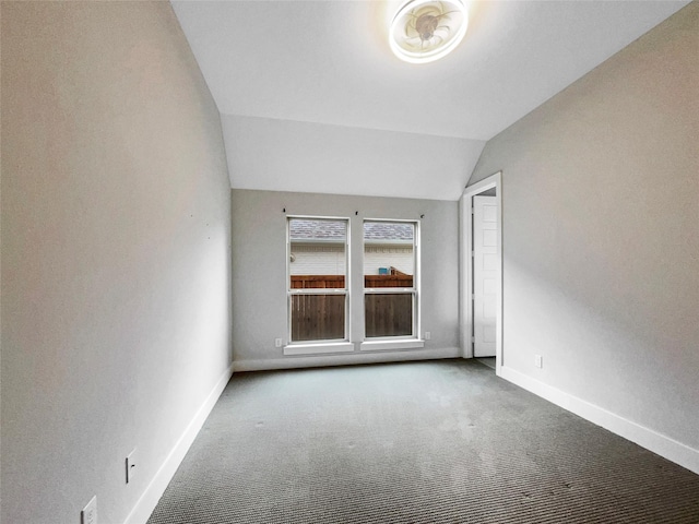 spare room featuring carpet floors and vaulted ceiling