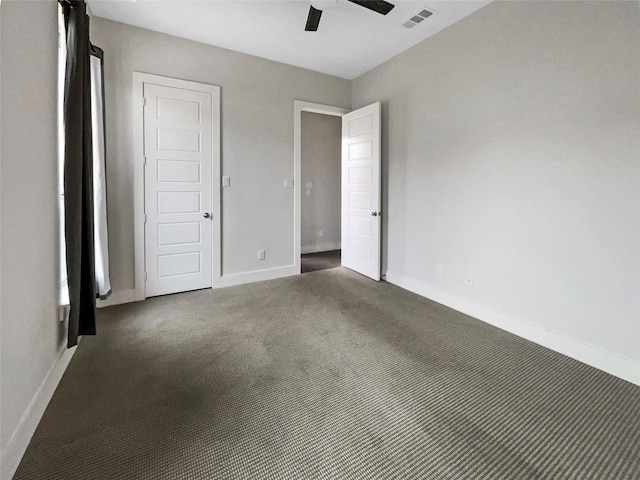 unfurnished bedroom featuring ceiling fan and dark carpet