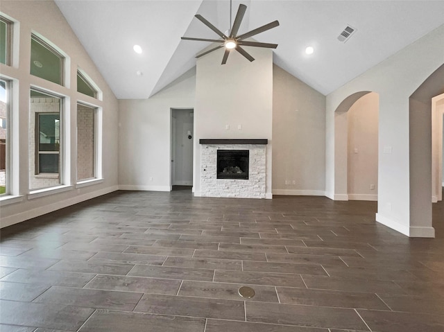 unfurnished living room with ceiling fan, a fireplace, and high vaulted ceiling