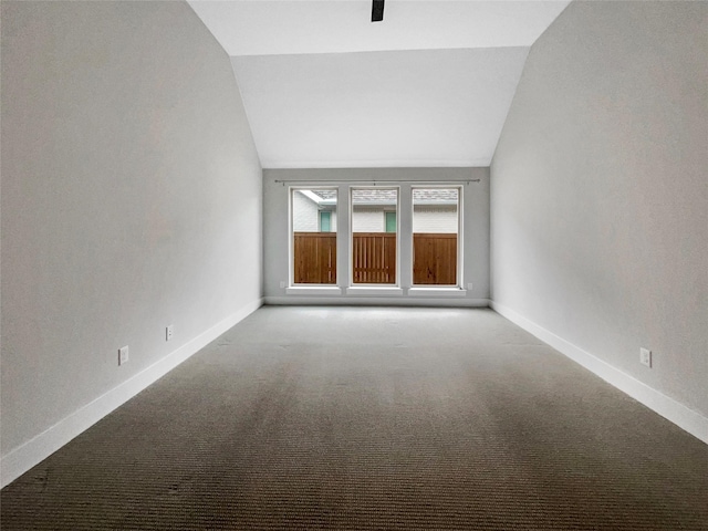 carpeted empty room with lofted ceiling