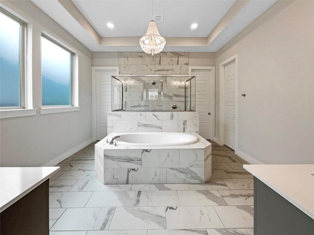 bathroom featuring a raised ceiling, vanity, and plus walk in shower