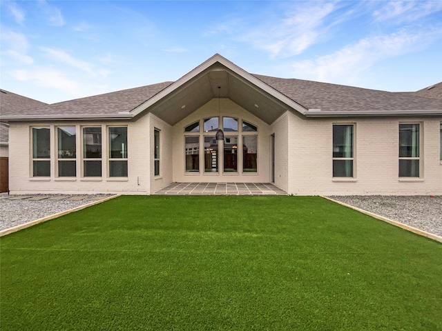 rear view of property featuring a patio area and a lawn