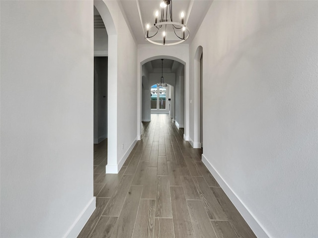 2701 Capitol Pl, Melissa, TX 75454 - corridor with a chandelier, arched walkways, wood tiled floors, and baseboards