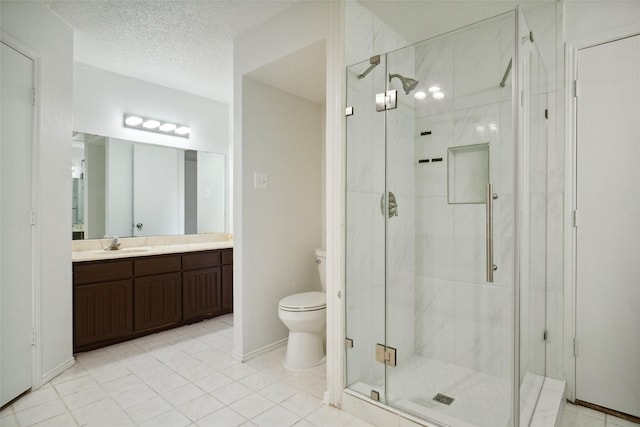 bathroom with tile patterned flooring, vanity, a textured ceiling, toilet, and walk in shower