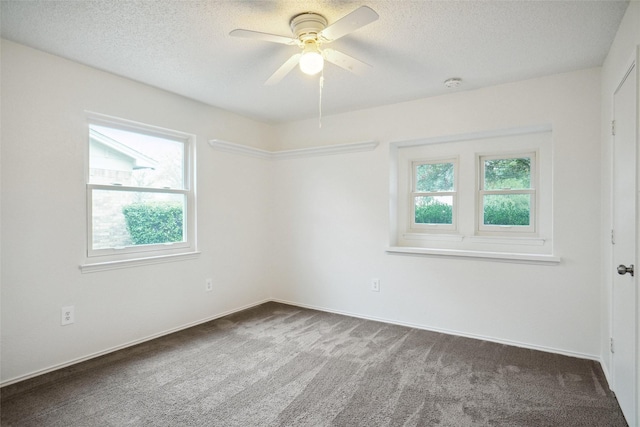 spare room featuring ceiling fan, a textured ceiling, and dark colored carpet