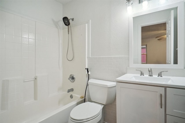 full bathroom featuring vanity, tub / shower combination, tile walls, and toilet