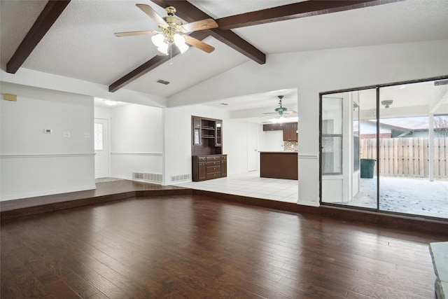 unfurnished living room with a healthy amount of sunlight, light hardwood / wood-style flooring, and vaulted ceiling with beams