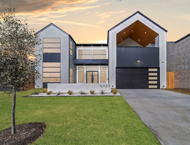 modern home featuring a garage and a yard