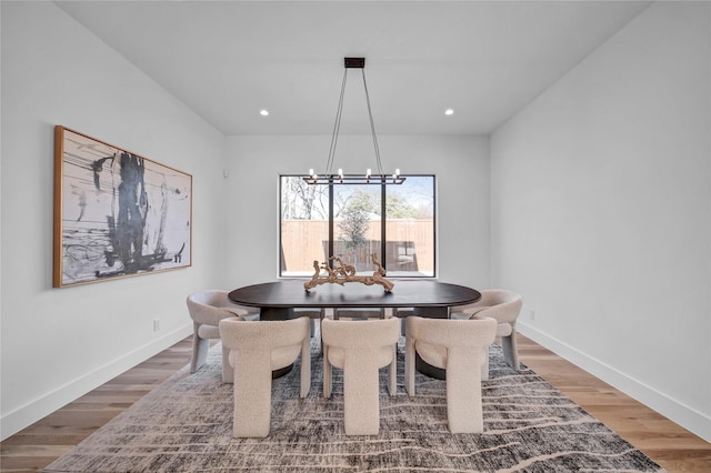 dining space with recessed lighting, baseboards, wood finished floors, and a chandelier