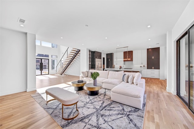 living room with recessed lighting, stairway, visible vents, and light wood-style flooring