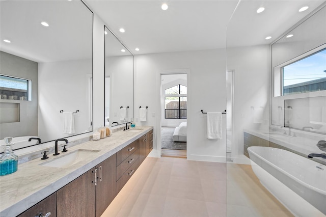 bathroom with vanity, a healthy amount of sunlight, and a bathtub