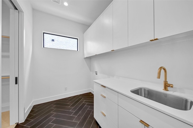 clothes washing area featuring cabinets, hookup for a washing machine, and sink