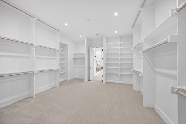 walk in closet featuring light colored carpet