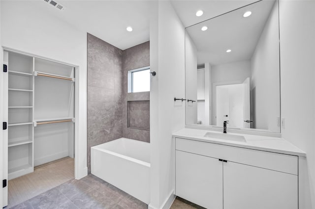 bathroom featuring vanity, visible vents, recessed lighting, bathtub / shower combination, and a spacious closet