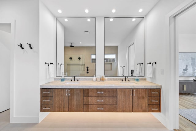 full bathroom with a shower stall, recessed lighting, double vanity, and a sink