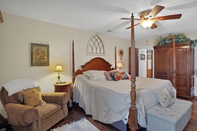 bedroom featuring ceiling fan, dark hardwood / wood-style floors, and a textured ceiling