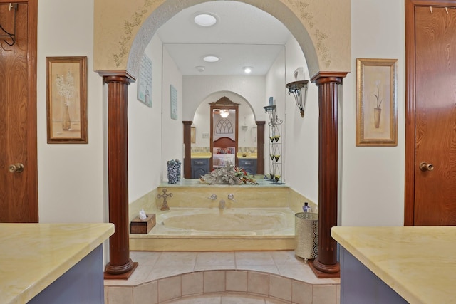 bathroom featuring vanity, tile patterned flooring, a washtub, and ornate columns