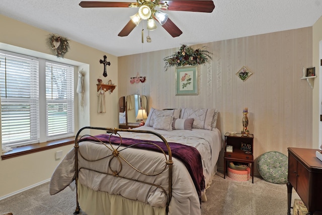 bedroom featuring ceiling fan, light carpet, and a textured ceiling