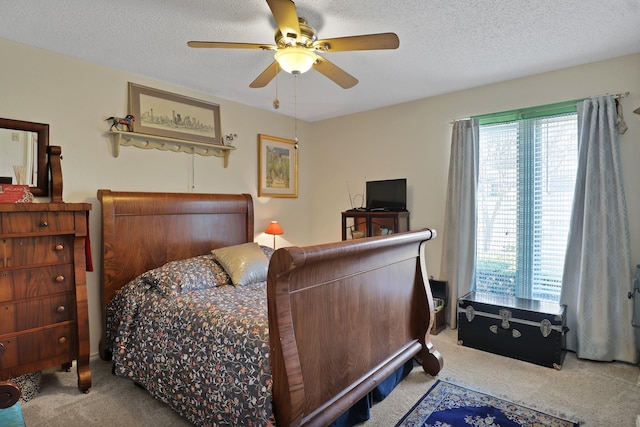 bedroom featuring light carpet, ceiling fan, and a textured ceiling