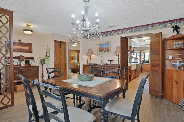 dining area with an inviting chandelier and a textured ceiling