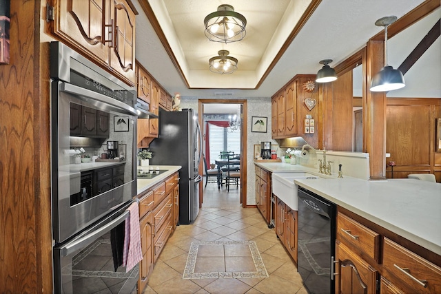 kitchen with pendant lighting, sink, light tile patterned floors, black appliances, and a raised ceiling