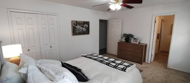 bedroom with a closet, a ceiling fan, and light colored carpet