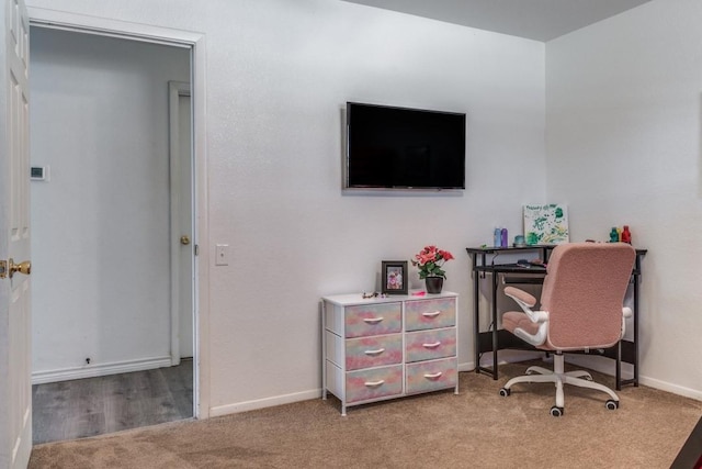 office space featuring light carpet and baseboards