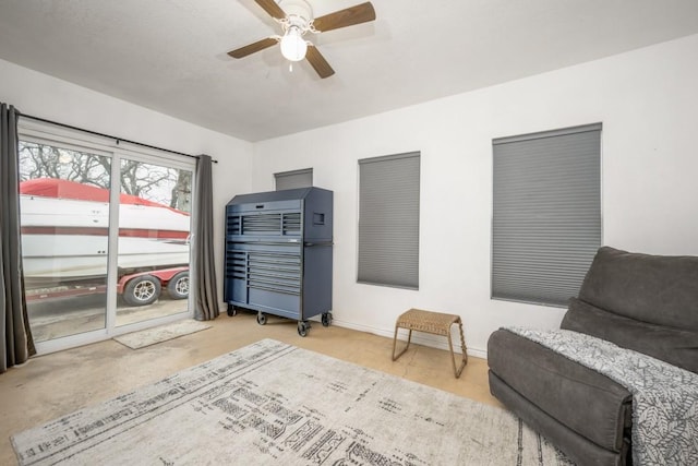 sitting room with ceiling fan and baseboards