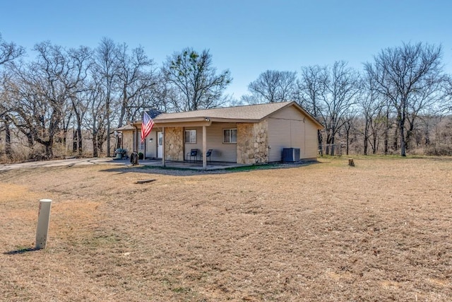 ranch-style house featuring a front lawn and central air condition unit