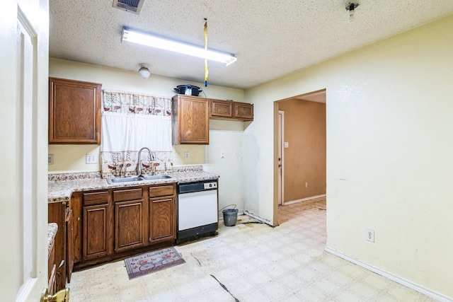 kitchen featuring dishwasher, sink, and a textured ceiling