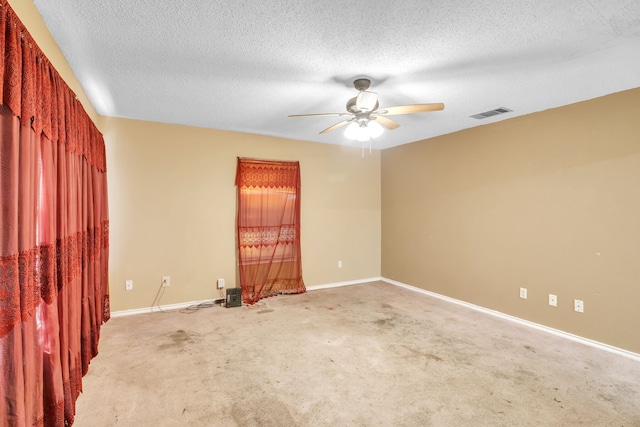 carpeted spare room with a textured ceiling and ceiling fan