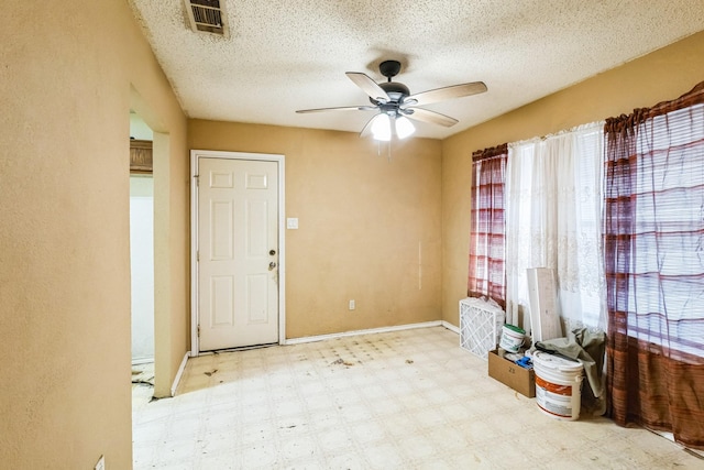 entryway with ceiling fan and a textured ceiling