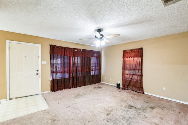 interior space featuring ceiling fan, carpet floors, and a textured ceiling