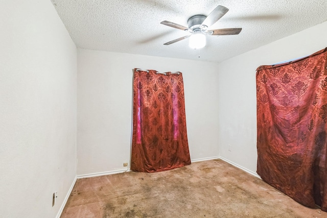 carpeted empty room with ceiling fan and a textured ceiling