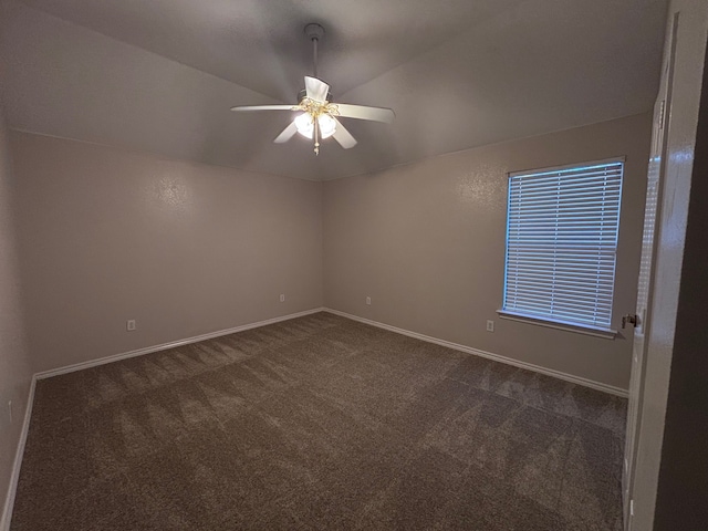 unfurnished room featuring dark colored carpet, ceiling fan, and baseboards