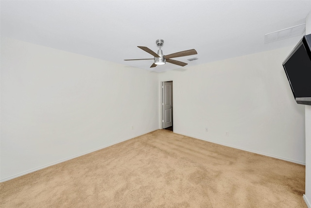 spare room featuring light carpet and ceiling fan