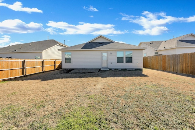 rear view of property featuring a yard